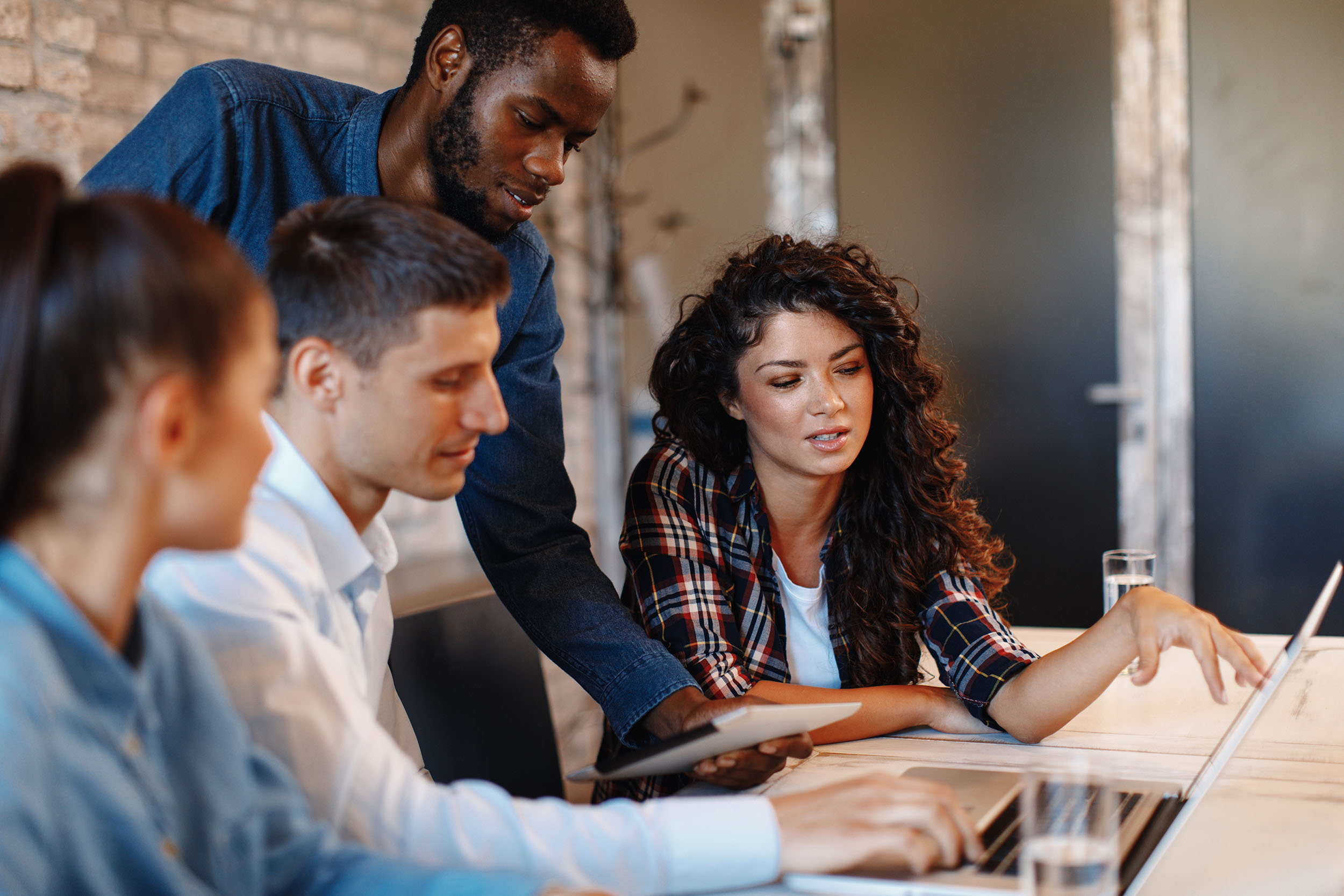 4 people work on a laptop