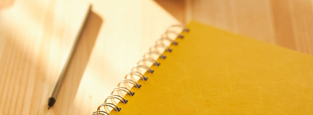 Un crayon à côté d'un répertoire jaune