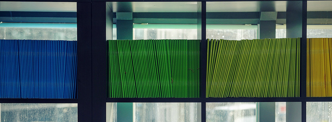 blue and green files on a shelf